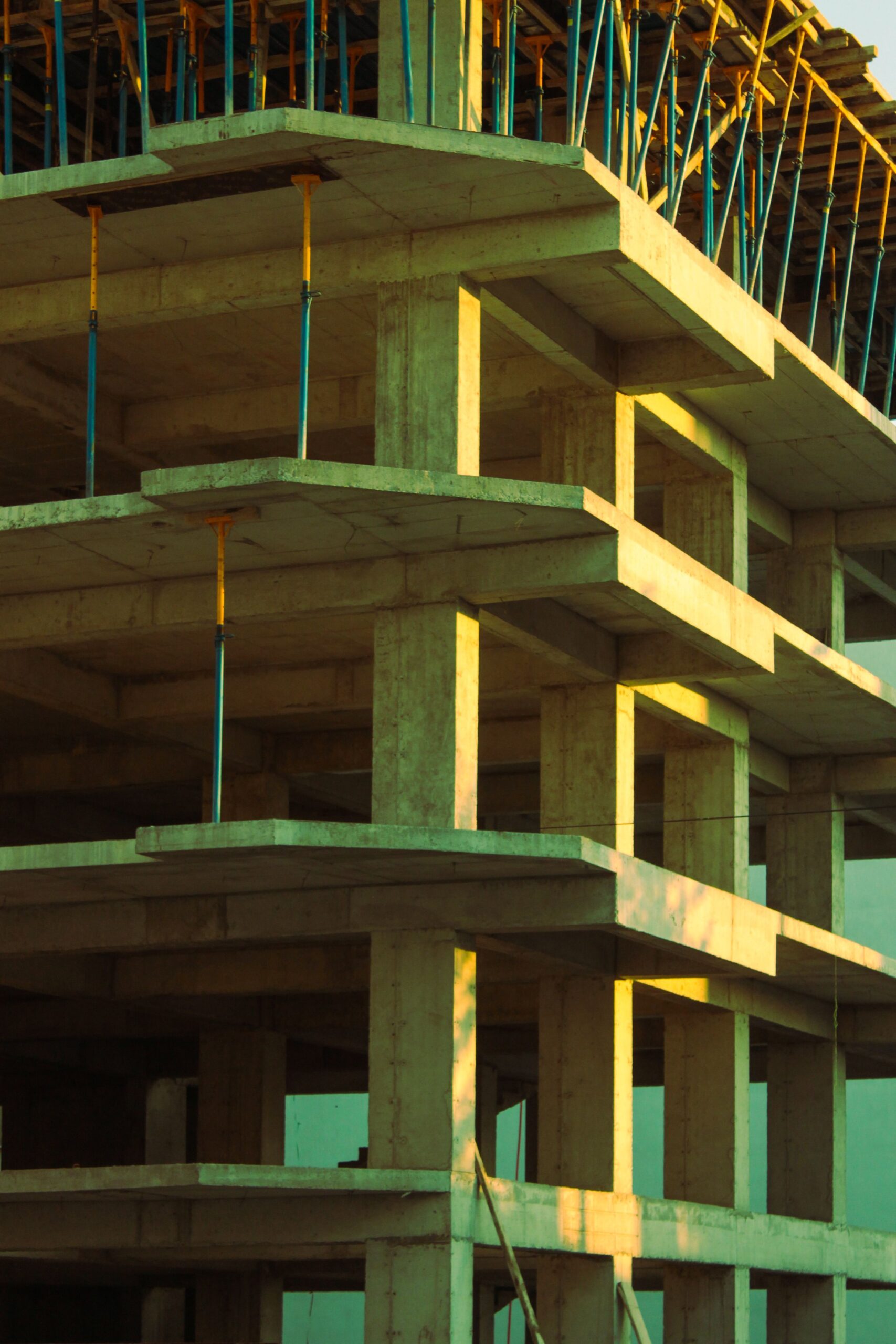Concrete building structure in early stages of construction captured at sunset, showcasing architectural framework.