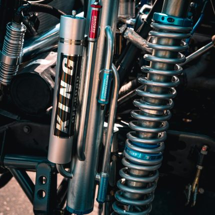 Detailed view of shock absorbers in an off-road vehicle, showcasing engineering complexity.