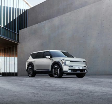 Kia EV9 electric SUV parked in an urban architectural environment, showcasing modern design.